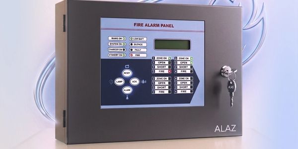 A grey fire alarm panel with control buttons and a key inserted.