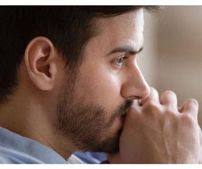 A man with short hair and a beard thinking. 