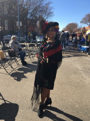 Woman in festive attire posing outdoors.