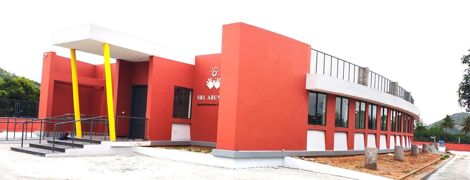 Red special school building with yellow pillars.