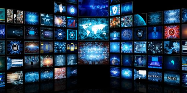 Multiple digital screens displaying futuristic technology and data visuals.