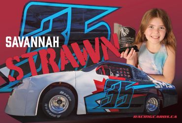 Young racer Savannah Strawn holding a trophy beside her race car.