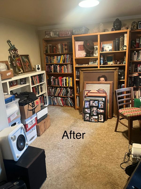 A neatly organized room with bookshelves and framed pictures.
