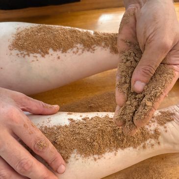 Application de gommage corporel au sable sur les jambes.
