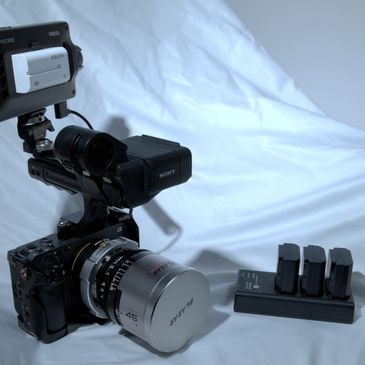 Professional video camera setup with batteries and charger.