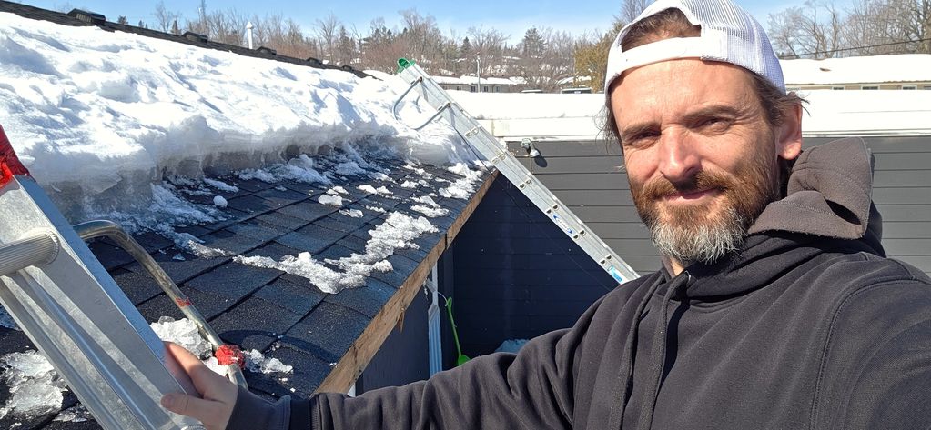 Murray Pro on a ladder removing a ice dam