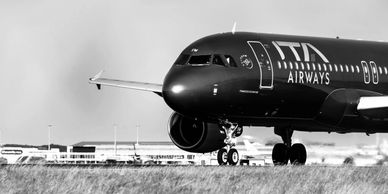 Black and white image of an ITA Airways airplane on the runway.