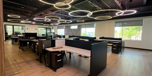 Modern office space with circular ceiling lights and modular desks.