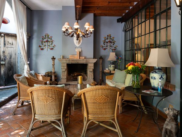 Cozy indoor seating area with wicker chairs, a fireplace, and warm lighting.
