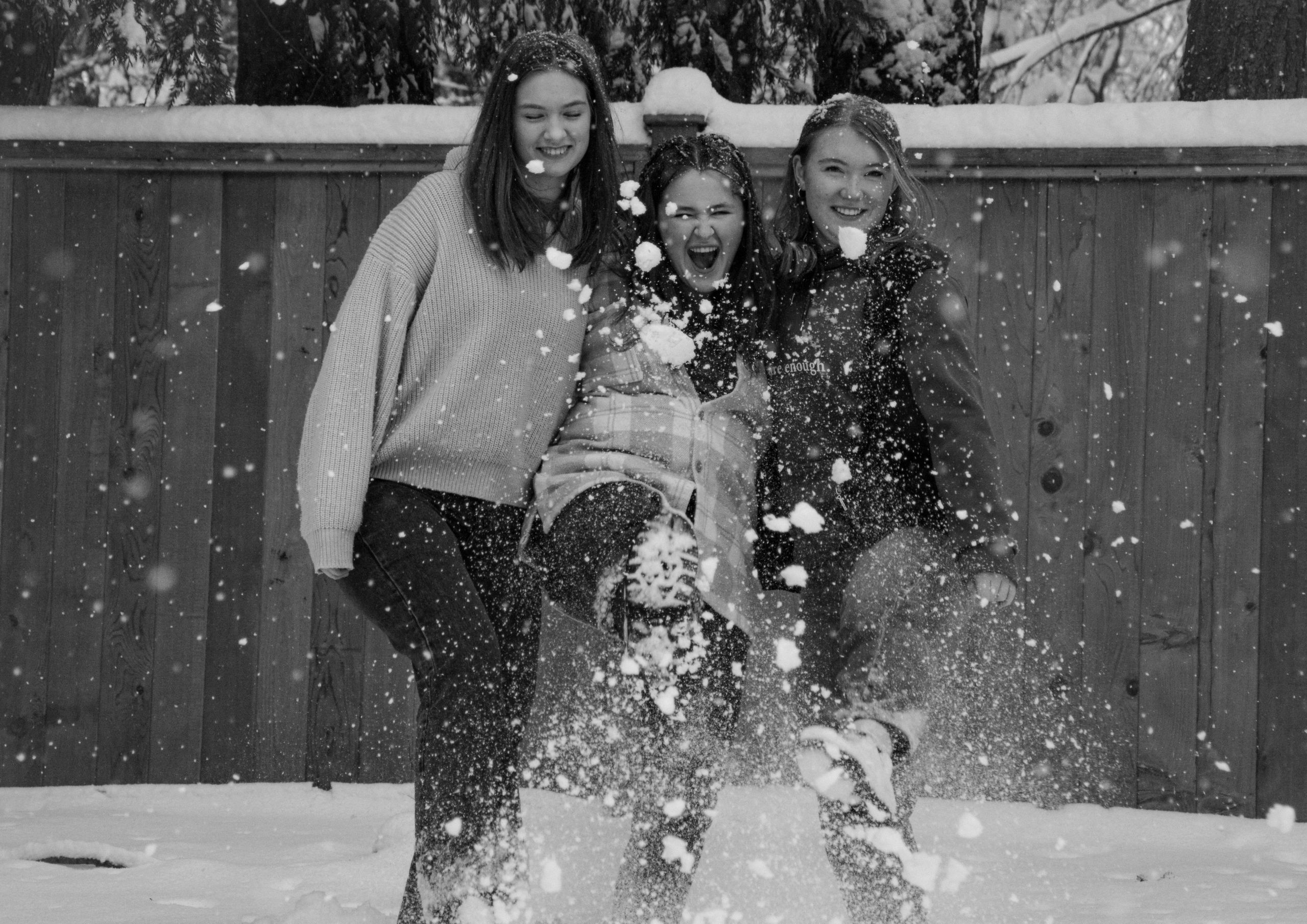 Three friends taking photos in the snow