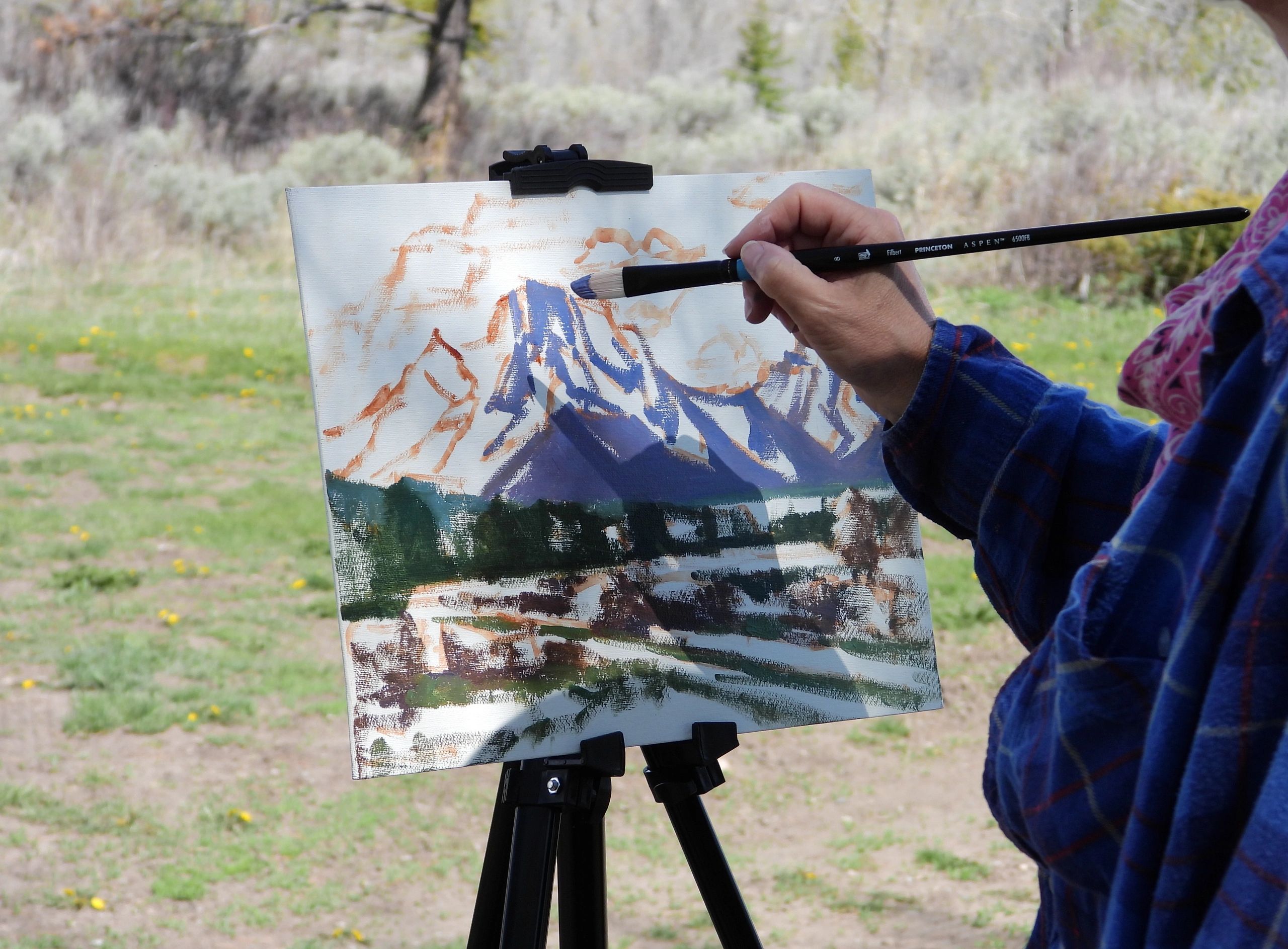 This is a photo of Lara plein air painting Mt. Moran in Grand Teton National Park.