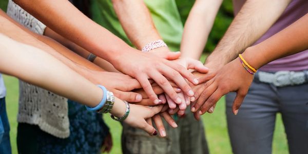 Hands stacked together showing unity.