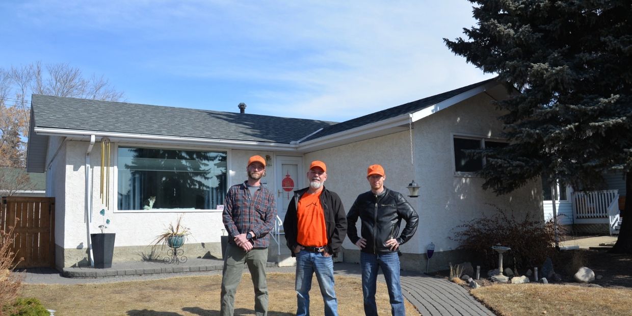 The Roofing Factory owners standing in front of a completed residential roof in Edmonton, Alberta.