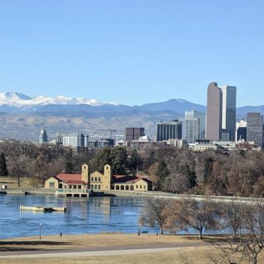 City skyline with mountains and a lake in the foreground.
