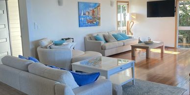 Bright living room with beige sofas and blue accents.