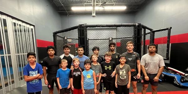 Wrestling students of all ages pose for group photo at Babak training facility