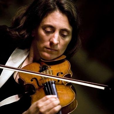 Woman playing the violin with focus.