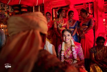 Bride smiling joyfully during a traditional wedding ceremony.