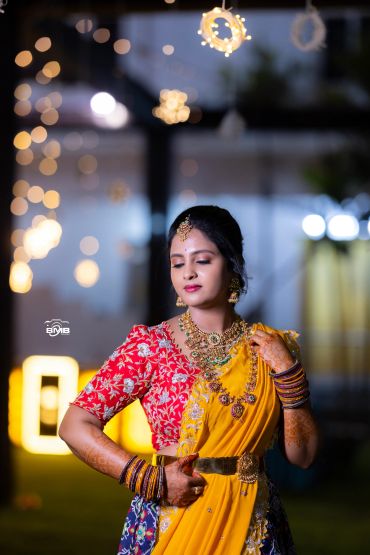 Woman in traditional Indian attire posing with closed eyes.