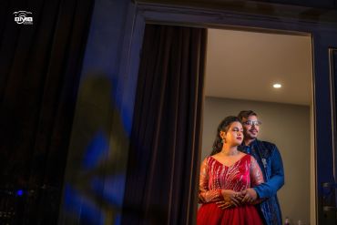 Couple posing in elegant traditional attire indoors.