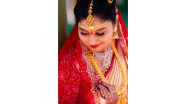 Indian bride in traditional attire with jewelry and henna.