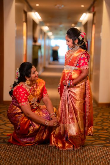Woman and girl in traditional Indian attire share a joyful moment.