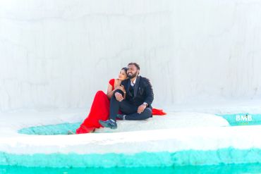 Couple sitting on icy blue and white landscape.