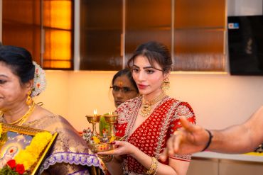 Traditional Indian woman holding a ceremonial tray with lamps.