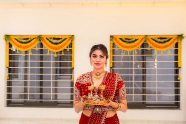 Woman in traditional attire holding a decorated plate with lights.