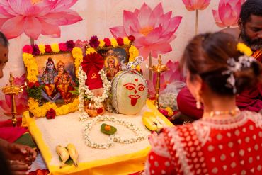 Traditional Hindu pooja setup with deities and devotees.