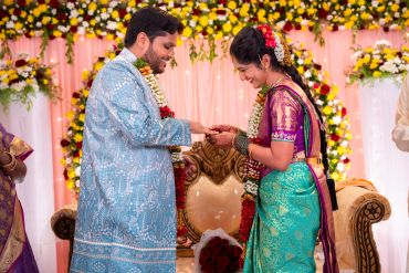 A couple exchanging rings during a traditional wedding ceremony.