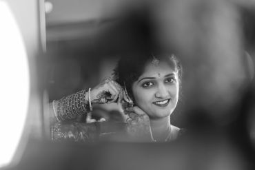 A woman smiling while looking in a mirror.