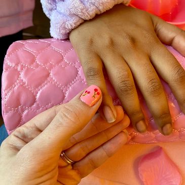 Two hands with a pink quilted background.