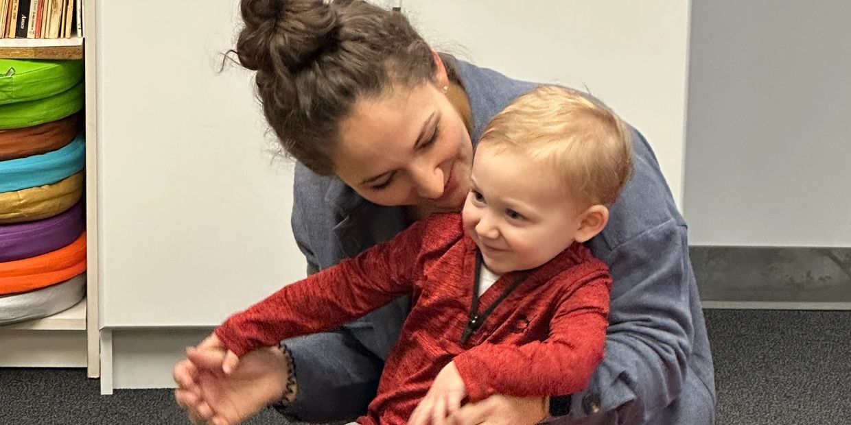 a mom holds a young boy on her lap