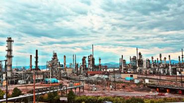 Industrial refinery complex under a cloudy sky.