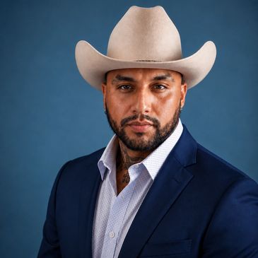 Hombre con sombrero vaquero y traje azul.