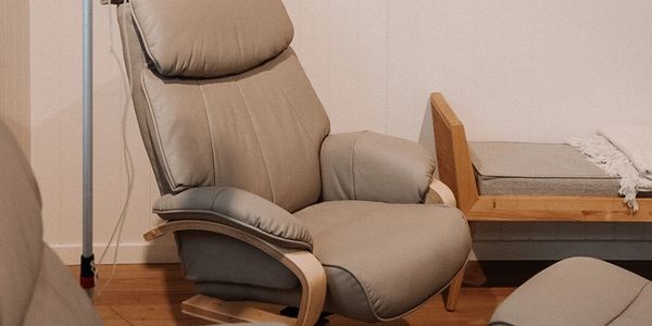 Comfortable beige armchair with wooden frame in minimalistic room.