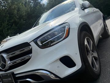 Front angled view of a white Mercedes-Benz SUV parked outdoors.