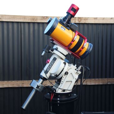 Advanced telescope with Astro-Physics mount and yellow optical tube.