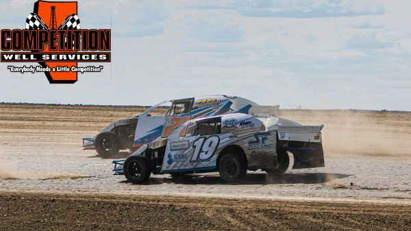Two modified race cars competing on a dirt track.
