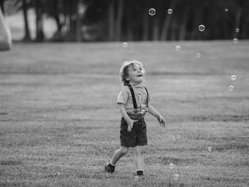 Birthday boy chasing bubbles 