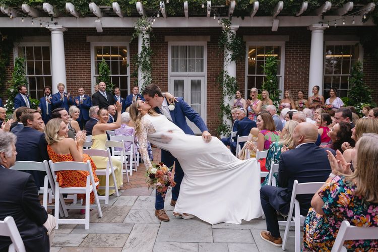 Bride and groom just after recessing down the aisle with their wedding party cheering them on 