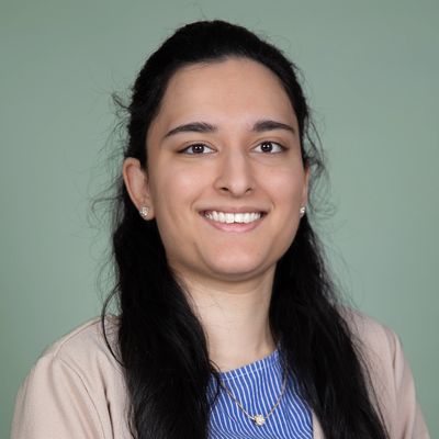 Smiling woman with long dark hair and professional attire.