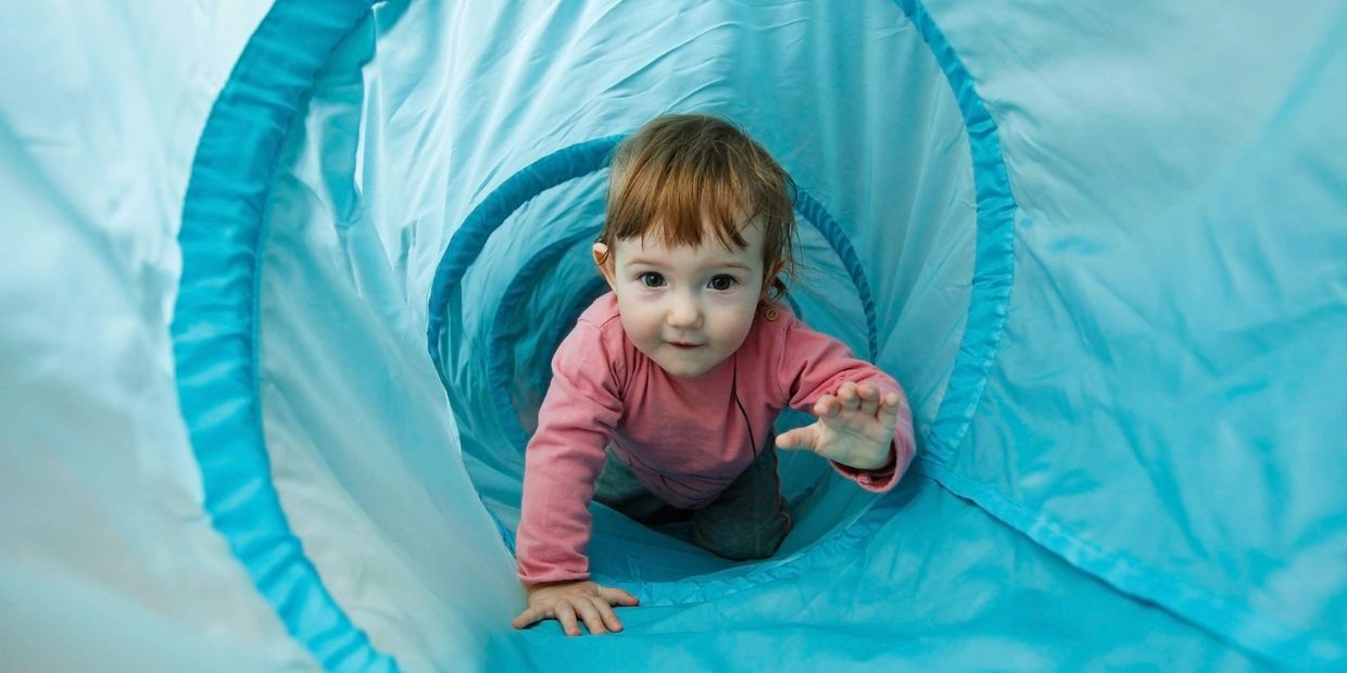 Girl crawling through tunnel