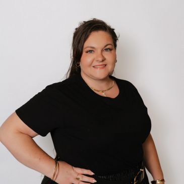 Smiling woman posing in black shirt.