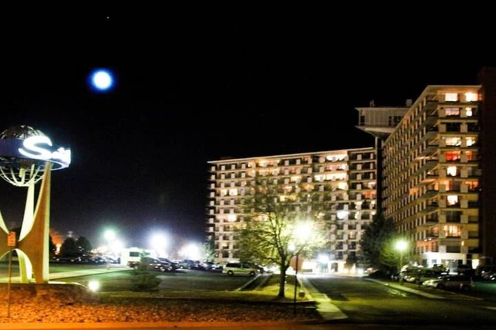 Illuminated apartment buildings at night with a unique sign on the left.
