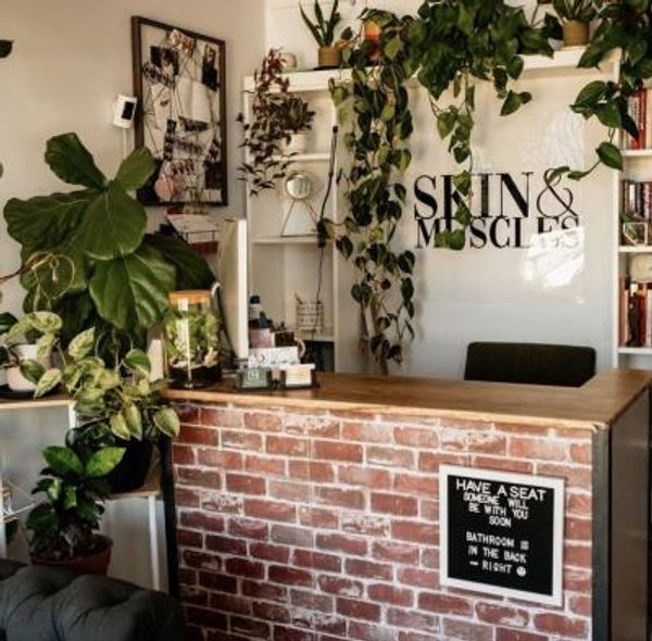 Cozy reception area with brick counter and hanging plants.