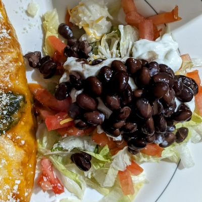 Taco salad with shredded lettuce, black beans, diced tomatoes, salsa, and sour cream.