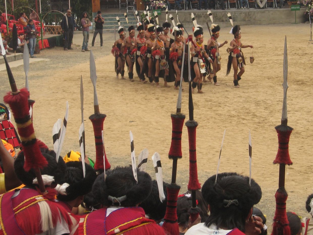 Traditional tribal dance performance with spears and costumes.