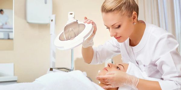 Licensed aesthetician conducts facial consultation and skin analysis.